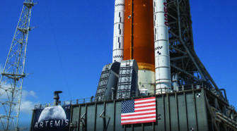View of lower half of NASA SLS rocket atop Mobile Launch Platform