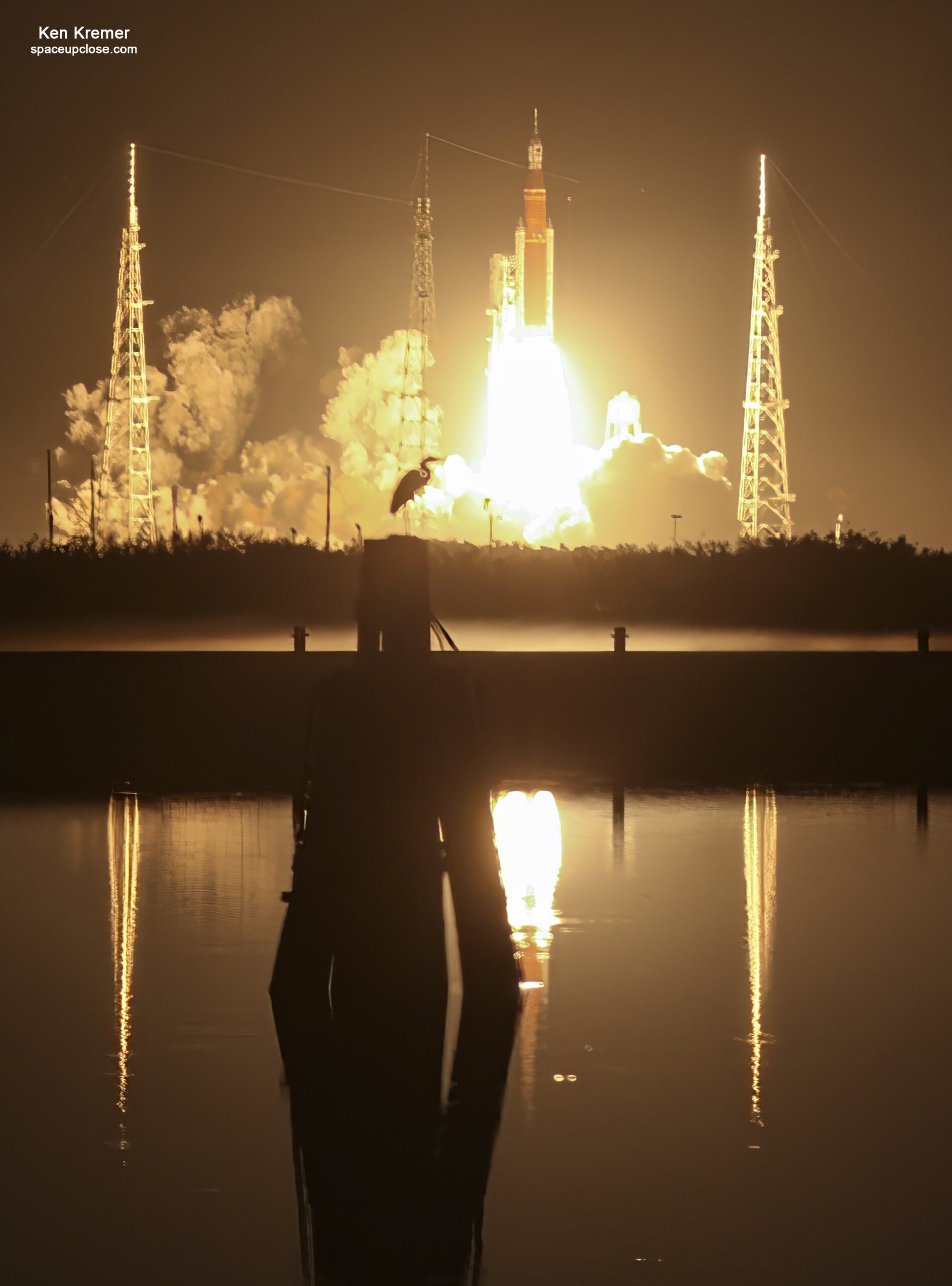 launch of sls artemis rocket with bird and water reflections